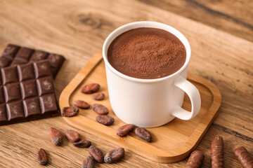 Cup of melted chocolate with chocolate beans on wooden table. Closeup