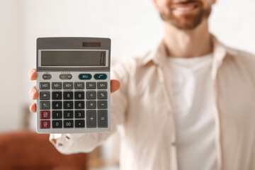 Smiling businessman with grey modern calculator in office