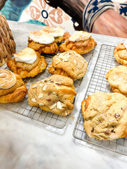 Assorted Gourmet Pastries and Cookies Topped with Meringue, Almonds, and Chocolate on a Wire Rack