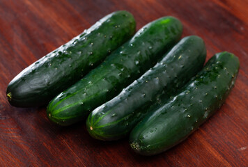 Many ripe cucumbers on wooden surface