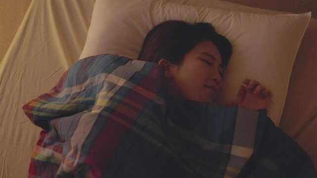 夜の寝室で幸せそうに眠る健康な日本人女性	
