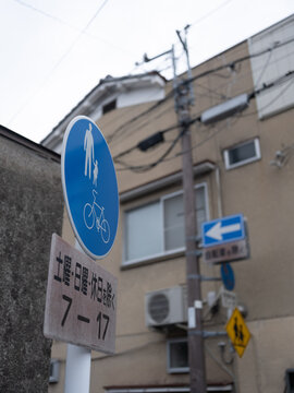 Urban Street Sign in Japan with Cyclist and Pedestrian Symbol on a Cloudy Day