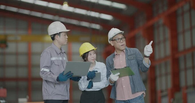A team of engineers professionals engages with a client during a consultation session at a bustling metal sheet factory, discussing project specifics and industry solutions.
