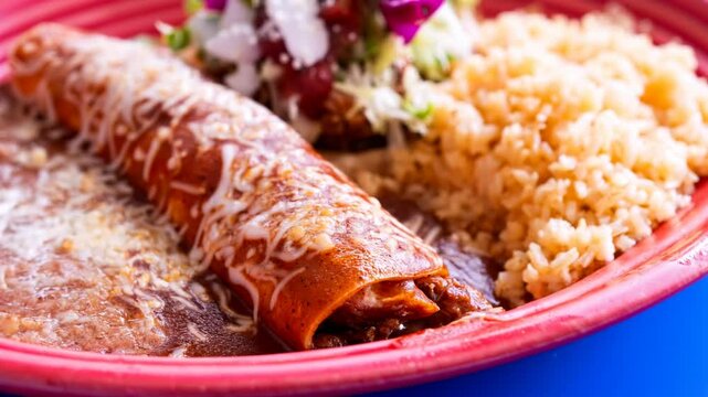 Mexican chicken enchilada with rice and refried beans close up