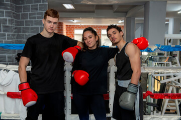Boxers posing together inside a boxing ring, teamwork and camaraderie in combat sports