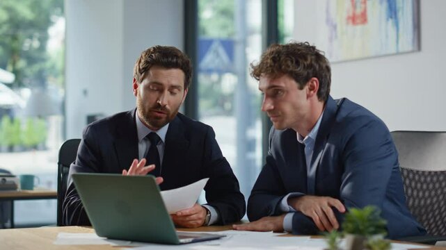 Smiling colleagues greeting laptop videocall in modern office space closeup