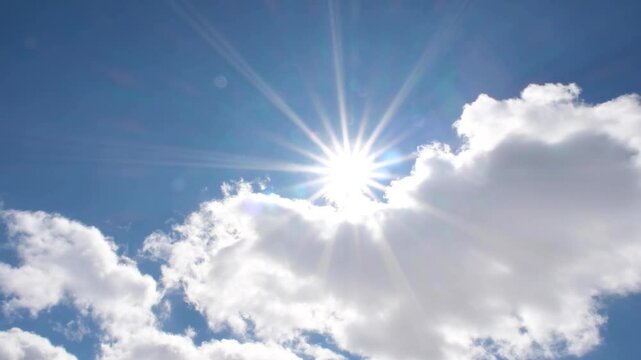 The sun peeking through the clouds in the blue sky