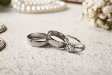 Silver wedding rings and engagement ring on white background. Closeup