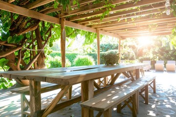 Fototapeta premium Wooden garden dining tables with benches under a pergola covered in green vines.