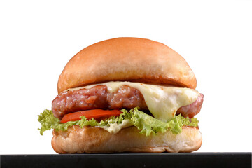 beef burger with sandwich bun salad onion and cheese fast food isolated on wooden table