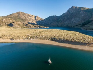 Sailboat on Grant Lake, mountain lake in the USA, surrounded by arid landscape and mountains. The...