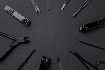 Set of pedicure tools on black background, flat lay. Space for text