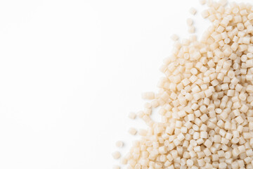 Pile of plastic granules on white background, top view. Space for text