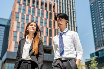 young man and woman in business attire walking confidently in urban setting, showcasing modern...