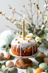 Easter cake with tall candle and white glaze on wooden stand. Orthodox holiday table concept.