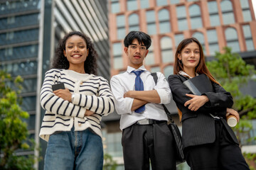 Fototapeta premium Confident young professionals standing outdoors in modern urban setting, showcasing teamwork and ambition. Their expressions reflect determination and readiness for success