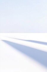 Serene Winter Landscape with Soft Shadows on Pristine Snow Under Clear Blue Sky