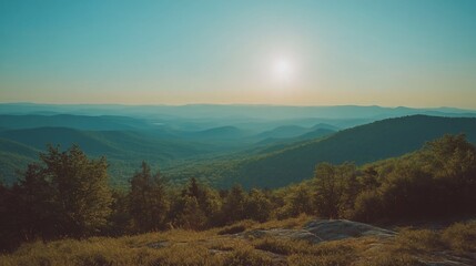 Fototapeta premium Scenic panorama of mountain ranges with forest under a clear morning sky
