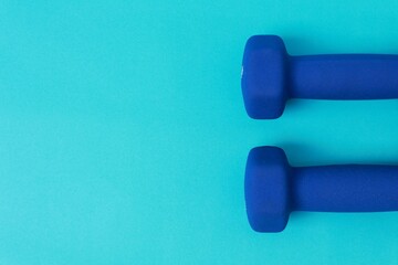 Two blue barbells on a blue background
