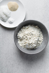 overhead view of mise en place for homemade steamed milk buns, ingredients for making mantou on a marble countertop