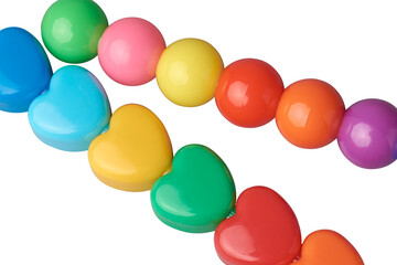 stack of colorful heart and sphere shaped beads isolated white background, vibrant small hearts and balls arranged as children toy, decoration or craft projects