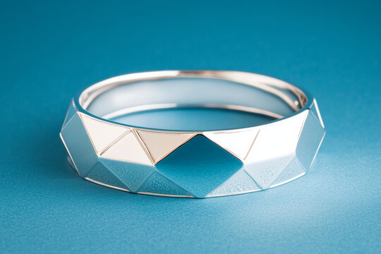 Silver geometric bangle gleams, reflecting light with subtle texture