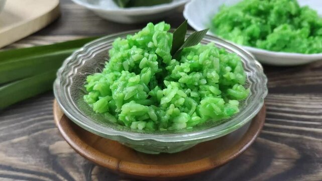 Green Sticky Rice Tape on a wooden table. It is a traditional Javanese Indonesian food with glutinous rice as the main ingredient or Oryza sativa L. Var. Glutinosa that is fermented.
