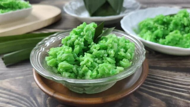 Green Sticky Rice Tape on a wooden table. It is a traditional Javanese Indonesian food with glutinous rice as the main ingredient or Oryza sativa L. Var. Glutinosa that is fermented.
