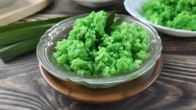 Green Sticky Rice Tape on a wooden table. It is a traditional Javanese Indonesian food with glutinous rice as the main ingredient or Oryza sativa L. Var. Glutinosa that is fermented.