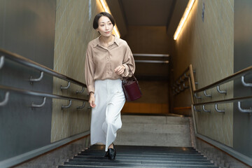 地下街から階段を上っている女性