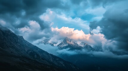 Majestic mountain peaks surrounded by dramatic clouds at sunset