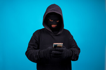 Hacker Using Smartphone Over Blue Background. Concept of Data Thief, Internet, Fraud and Cyber...