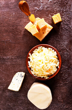 Shredded mozzarella and red cheddar cheese on cutting board