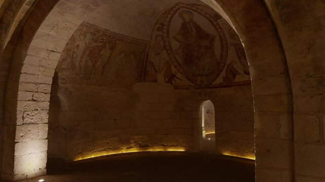 Ancient crypt with medieval frescoes, stone arches, and warm lighting, Saint-Aignan