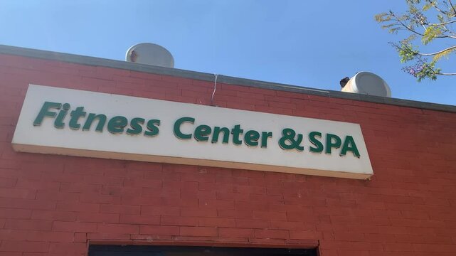 Hotel sign written Fitness Center and Spa on red brick wall low angle