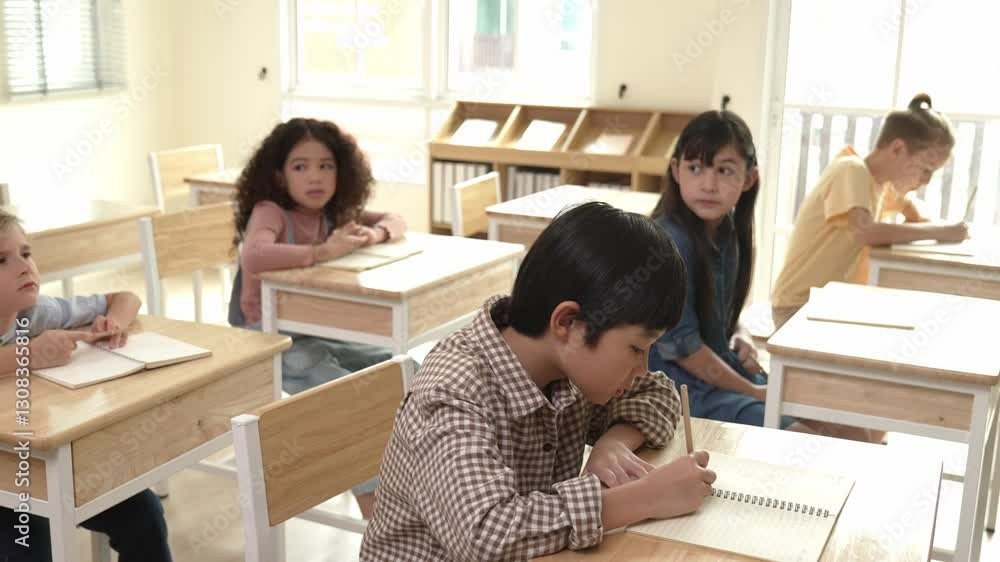 Poster asian skilled student working on classwork or doing test while sitting at classroom. diverse childre