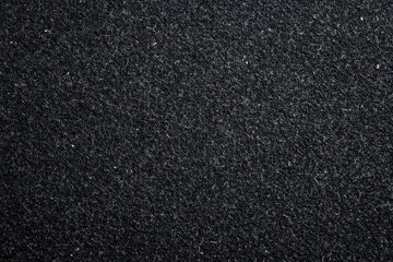 Fototapeta premium Flat black textured background with subtle noise and scattered white specks, minimalist concept for corporate branding and editorial layouts.