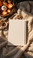 Cozy spiral notebook resting on soft blanket in warm indoor light, creativity