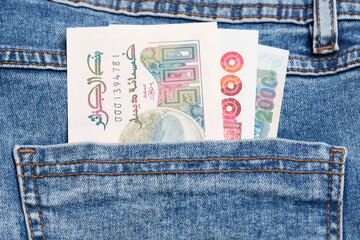 Algerian dinar in the pocket of blue jeans
