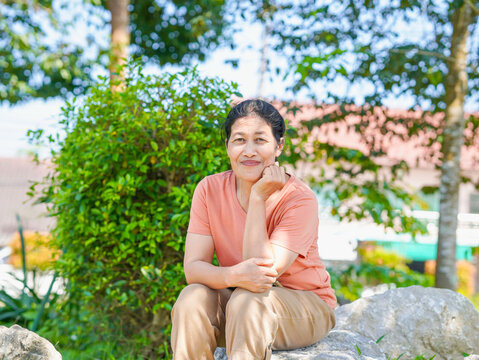 Lifestyle Health Care. Senior woman sitting enjoy with environment outdoor park nature background. Wellness self care elderly people in daily life. Vacation activities and happiness relax time. - Powered by Adobe