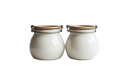 Two off-white ceramic jars with wooden lids and metal clasps sit side by side against a black background.