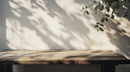 Wooden Table with Soft Shadows and Green Leaves on Wall Background