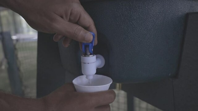 man drinking glass of water at sports drinking fountain, close up shot, raw c-log 8bits video HD slow motion