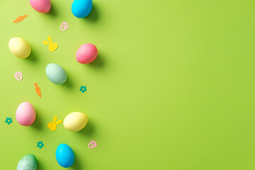 Colorful Easter eggs and festive decorations on a vibrant green background. Flat lay, minimal style.