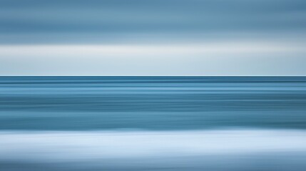 Serene blue ocean under a dramatic cloudy sky with copy space for artistic use and evocative beach atmosphere