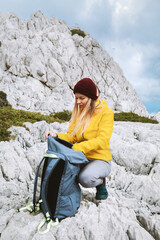 Naklejka premium Woman packing her backpack in mountains travel solo girl hiking in Greece active adventure lifestyle, female traveler exploring Rhodes island autumn season vacations outdoor trip
