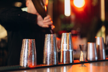 Bartender Preparing Drinks Using Shakers with Warm Ambient Lighting