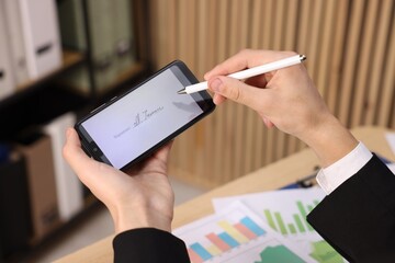 Electronic signature. Man using stylus and smartphone at table indoors, closeup