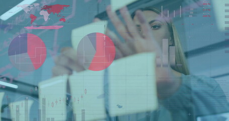 Image of charts processing data over caucasian casual businesswoman brainstorming at office