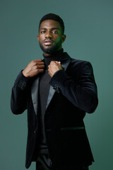 Elegant young man in black tuxedo and turtleneck exudes confidence and sophistication